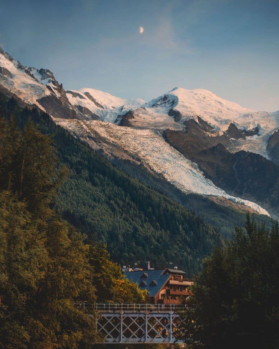 Le glacier des Bossons au-dessus de la forêt et d'un chalet de la vallée de Chamonix