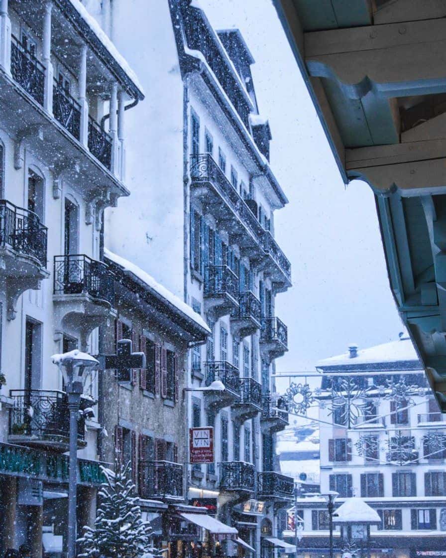 Rue enneigée du centre de Chamonix, façades d'hôtels anciens sous la neige