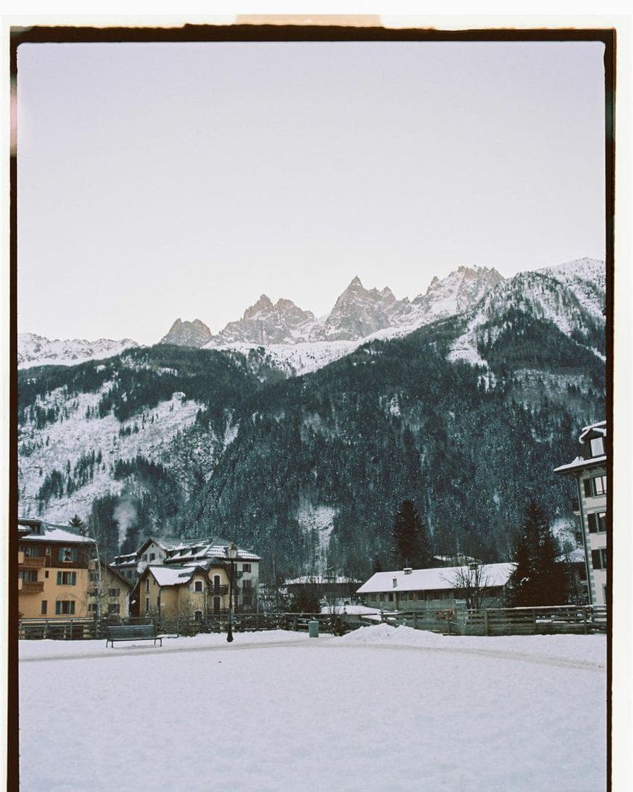 Les aiguilles de Chamonix au-dessus d'un champ enneigé et des bâtiments de la station