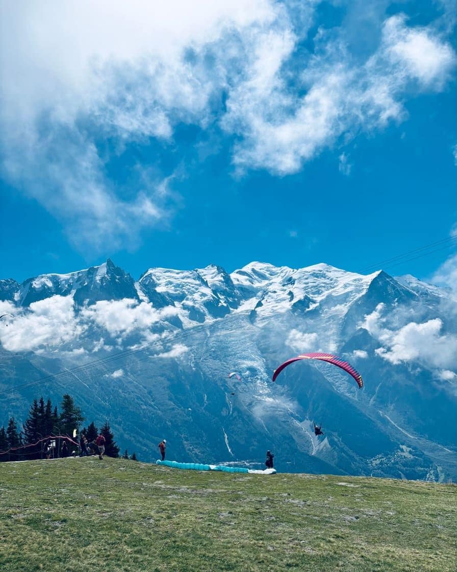 Décollage de parapentes sur un pré d'altitude du balcon sud, face au massif du Mont-Blanc et au glacier des Bossons