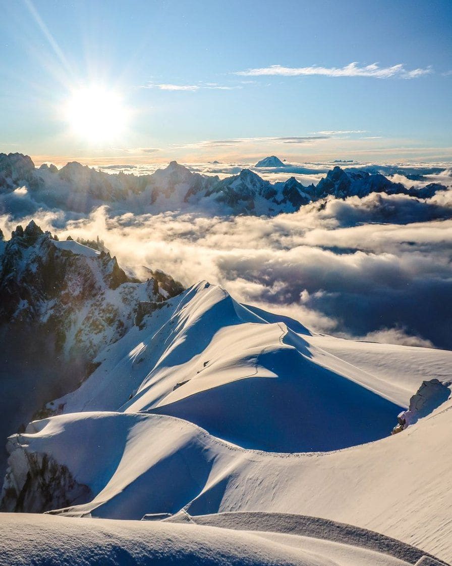Soleil sur les crêtes enneigées du massif du Mont-Blanc, mer de nuages au loin