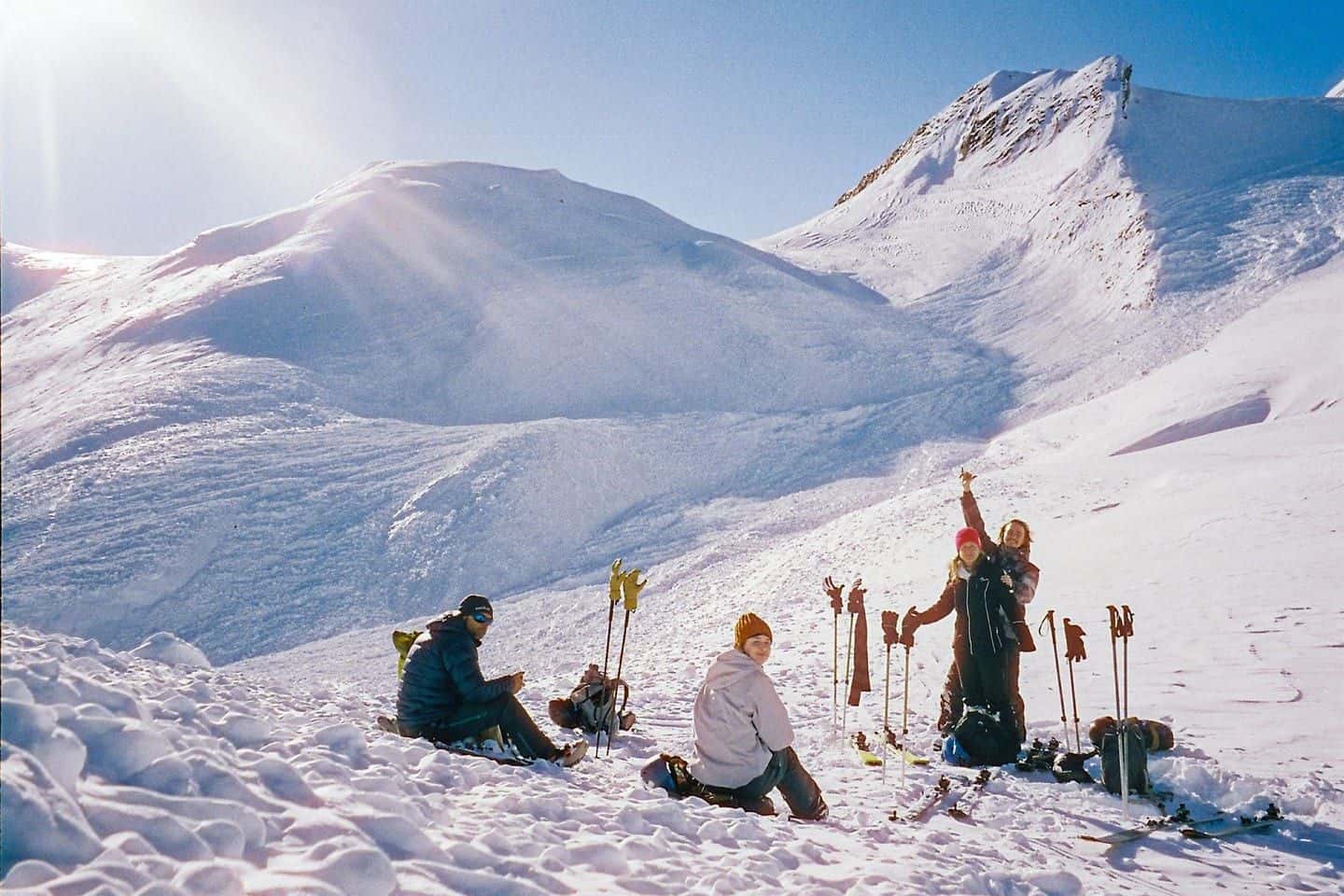 A group of skiers taking a break in the sun on a snowy slope of the Mont Blanc massif above Chamonix