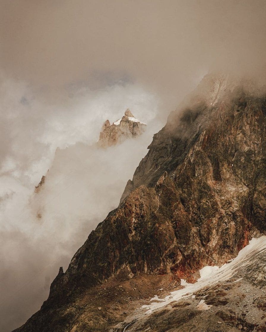 Versants de montagne enveloppés de nuages au-dessus de la vallée