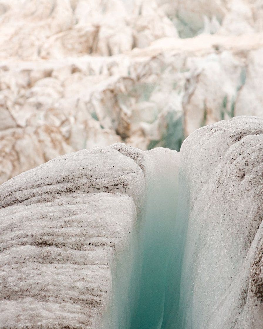Deep crevasse in a glacier of the massif, walls of bluish ice